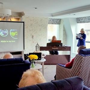 A service in a care home with leaders singing and playing keyboard.