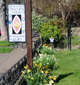 The sign for the church surrounded by spring flowers