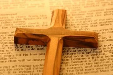 a wooden cross on an open bible